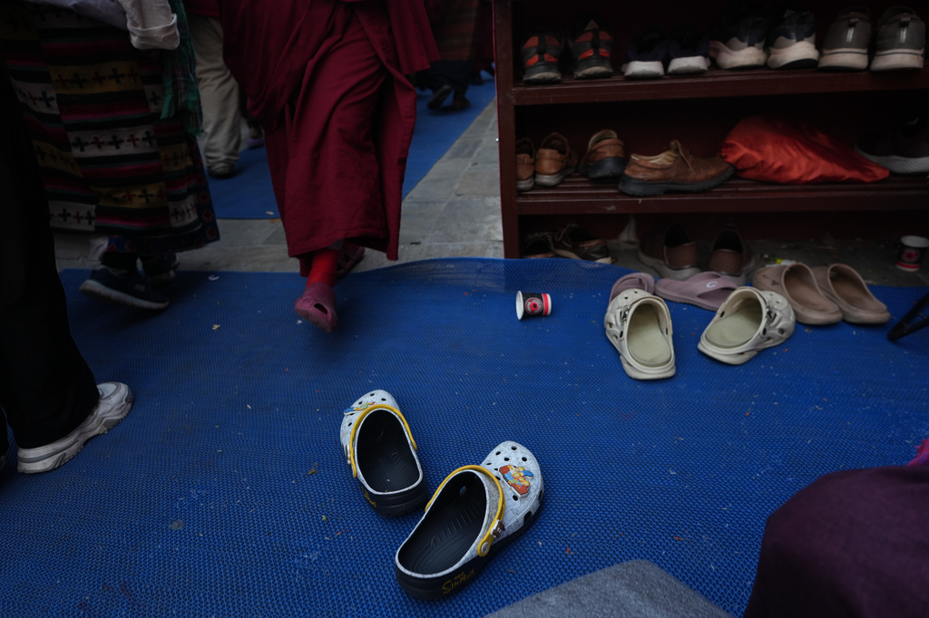 Crocs decorated with Jibbitz charms of The Simpsons, belonging to U.S.-born Buddhist lama Jalue Dorje, sit outside a prayer hall at Shechen Monastery in Kathmandu, Nepal, on Sunday, April 12, 2026. (AP Photo/Luis Andres Henao)