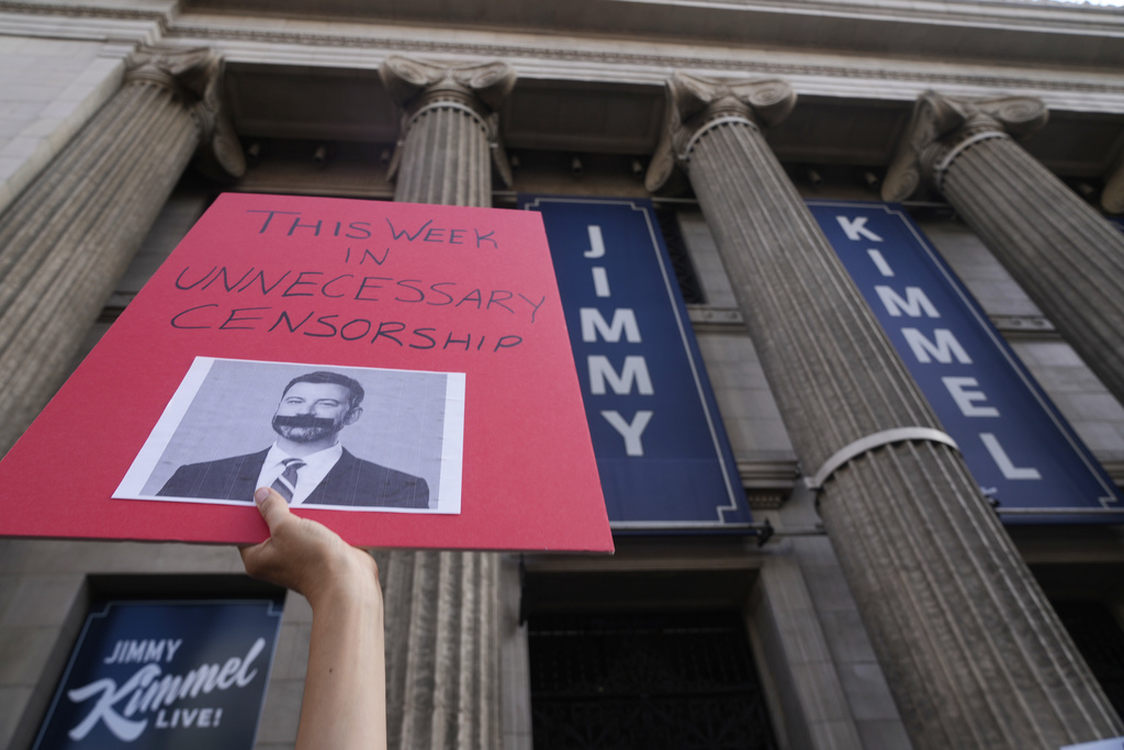 A demonstrator holds a sign outside El Capitan Entertainment Centre, where the late-night show "Jimmy Kimmel Live!" is staged on Thursday, Sept. 18, 2025, in Los Angeles. (AP Photo/Damian Dovarganes)