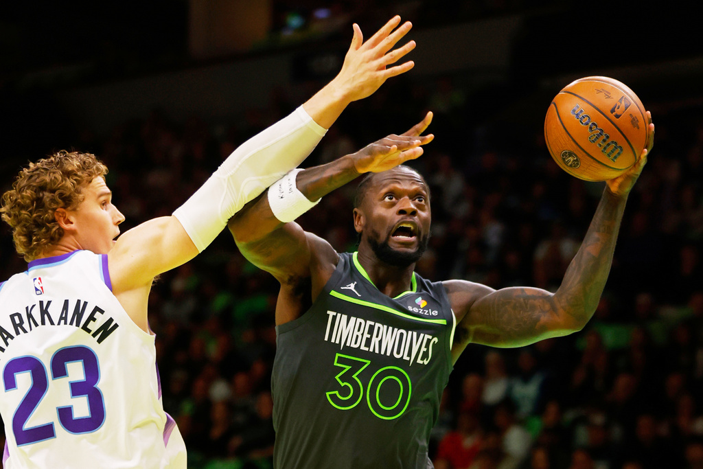 Minnesota Timberwolves forward Julius Randle (30) goes to the basket past Utah Jazz forward Lauri Markkanen (23) in the first quarter of an NBA Cup basketball game Friday, Nov. 7, 2025, in Minneapolis. (AP Photo/Bruce Kluckhohn)
