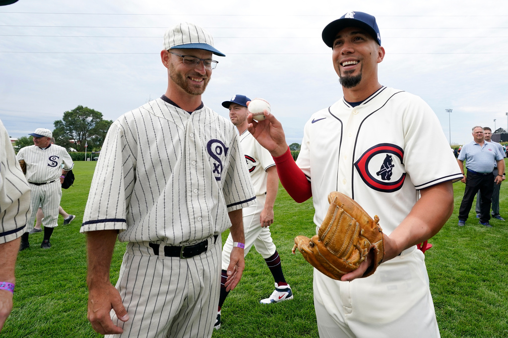 FILE - Field of Dreams "ghost" player Russ Bolibaugh, left, of Dyersville, Iowa, talks with Chicago Cubs center fielder Rafael Ortega, right, before a baseball game against the Cincinnati Reds at the Field of Dreams movie site, Aug. 11, 2022, in Dyersville, Iowa. (AP Photo/Charlie Neibergall, File)