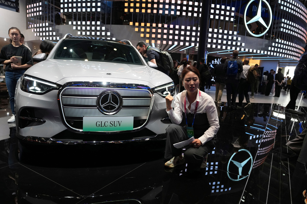 FILE - A vlogger promotes the GLC SUV at the Mercedes-Benz booth during Auto China 2026 in Beijing, on April 24, 2026. Major German carmakers saw sharp quarterly sales declines in China, as domestic demand weakened and competition heats up in the world’s biggest auto market. (AP Photo/Ng Han Guan)
