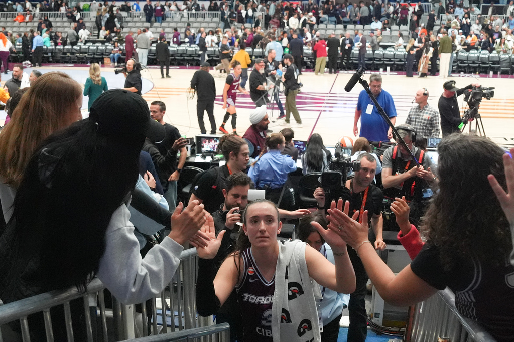 Toronto Tempo's Marina Mabrey, center, high fives-fans as she comes off the court after her team's first WNBA basketball game, against the Washington Mystics, in Toronto Friday, May 8, 2026. (Chris Young/The Canadian Press via AP)