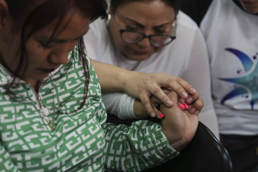People pray prior to a hearing for seven people accused of responsibility for a fire at a government-run facility for at-risk girls that killed 41 girls in 2017, in Guatemala City, Tuesday, Aug. 12, 2025. (AP Photo/Moises Castillo)