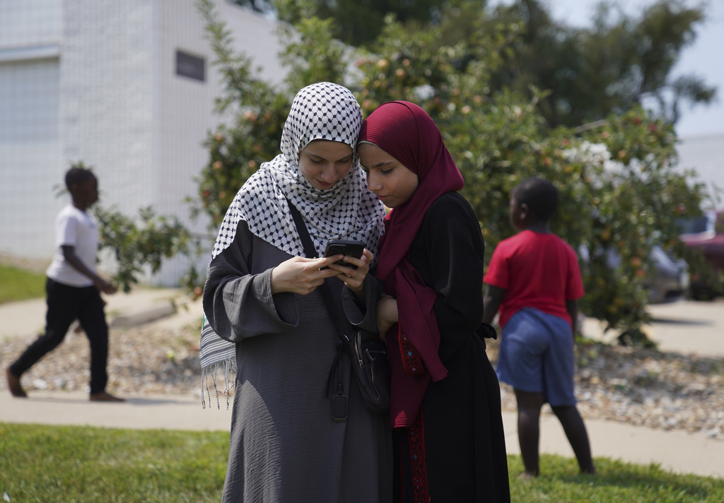 Two young girls stand together outside of the Islamic Center of Cedar Rapids after Friday prayer on Aug. 8, 2025, in Cedar Rapids, Iowa. (AP Photo/Jessie Wardarski)