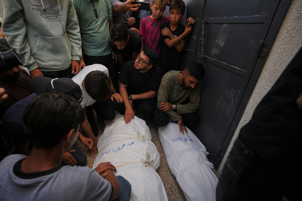 Mourners attend the funeral of Palestinians who were killed in an Israeli army strike on a cafe at the Gaza port the previous day, at Shifa Hospital in Gaza City, Wednesday, Aug. 19, 2026. (AP Photo/Jehad Alshrafi)