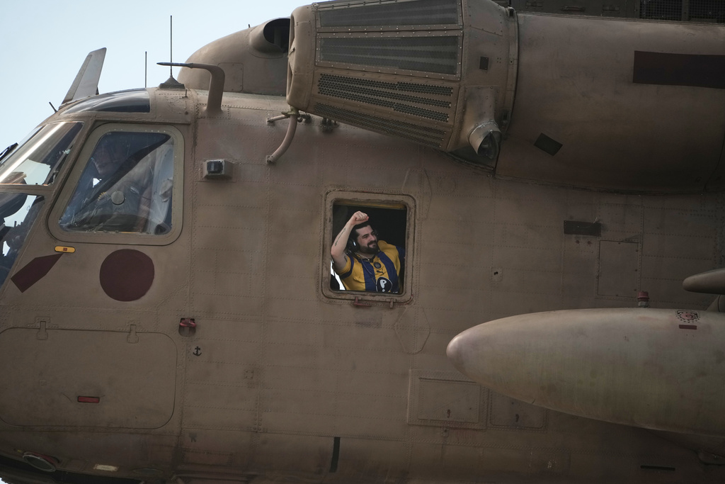 Ziv Berman, an Israeli hostage released from the Gaza Strip gestures from the window of a helicopter landing at the Sheba Medical Center in Ramat Gan, Israel, Tuesday, June 7, 2016. (AP Photo/Leo Correa)