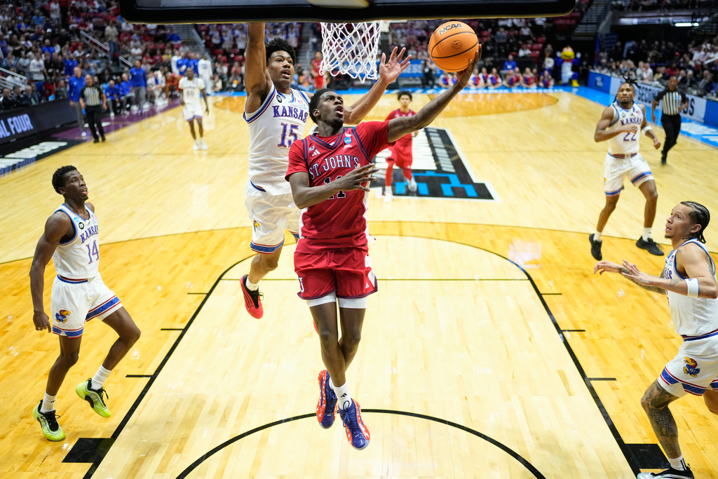 St. John's guard Ian Jackson (11) shoots around Kansas forward Bryson Tiller (15) during the second half of a game in the second round of the NCAA college basketball tournament Sunday, March 22, 2026, in San Diego. (AP Photo/Mark J. Terrill)