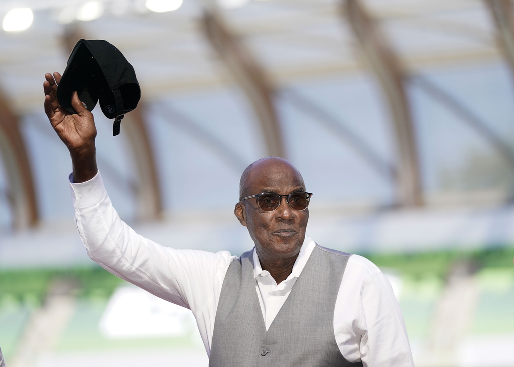 FILE - Bobby Kersee holds up his hat as he is honored as the 2023 USATF Legend Coach of the Year the during the U.S. track and field championships in Eugene, Ore., Saturday, July 8, 2023. (AP Photo/Ashley Landis, File)