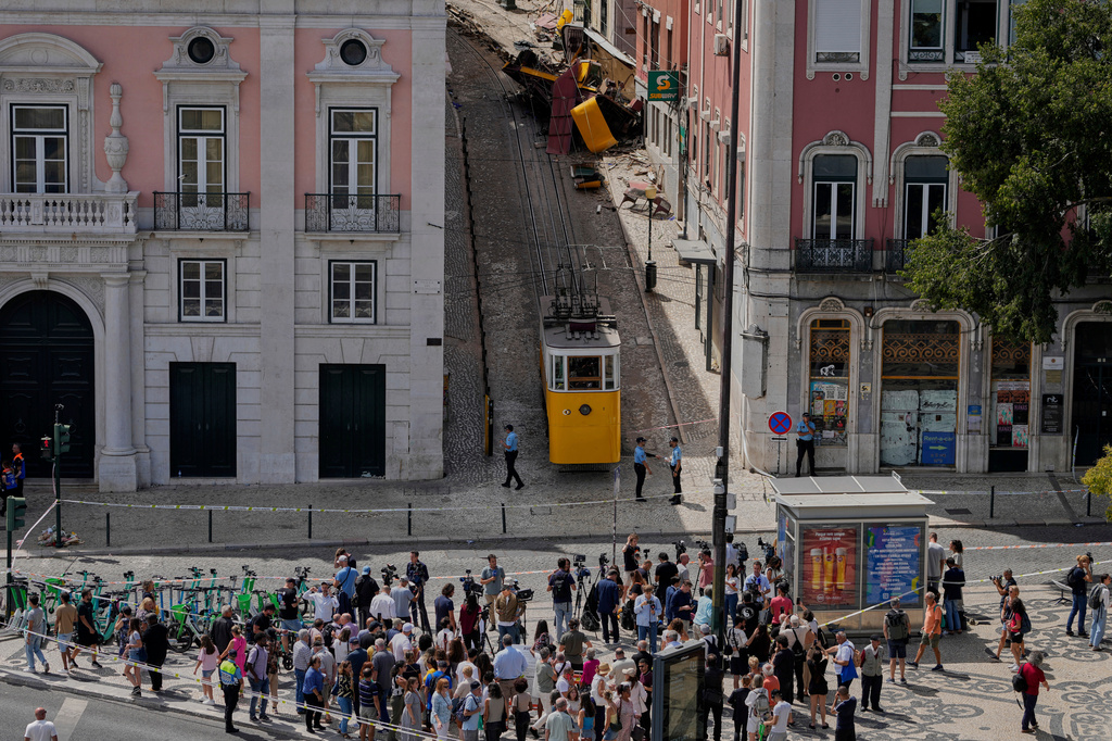 FILE - People look at a streetcar that derailed and crashed in Lisbon, Portugal, Sept. 4, 2025. (AP Photo/Armando Franca, File)