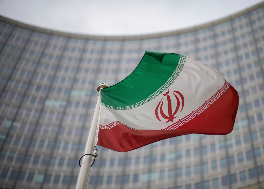 FILE -A national flag of Iran waves in front of the building of the International Atomic Energy Agency, IAEA, in Vienna, Austria, Dec. 17, 2021. (AP Photo/Michael Gruber, File)