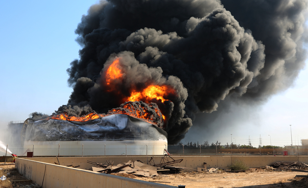 Flames and thick black smoke rise from a fuel storage tank at the Zawiya oil refinery following a drone strike in Zawiya, Libya, Tuesday, Aug. 11, 2026. (AP Photo/Yousef Murad)