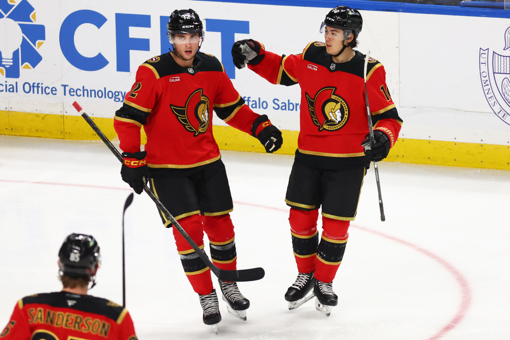 Ottawa Senators center Shane Pinto (12) celebrates his goal with defenseman Jordan Spence (10) during the third period of an NHL hockey game against the Buffalo Sabres Wednesday, Oct. 15, 2025, in Buffalo, N.Y. (AP Photo/Jeffrey T. Barnes)