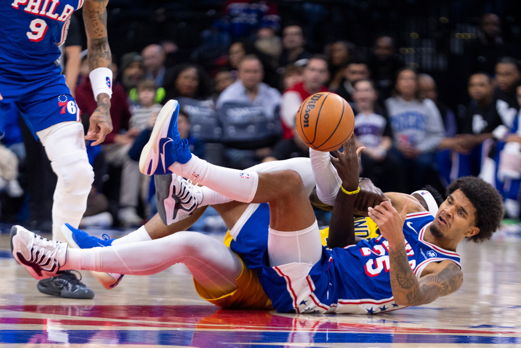 Philadelphia 76ers' Dom Barlow, front right, passes the ball that he took away from Indiana Pacers' Pascal Siakam, back right, while on the floor during the first half of an NBA basketball game, Monday, Jan. 19, 2026, in Philadelphia. (AP Photo/Chris Szagola)