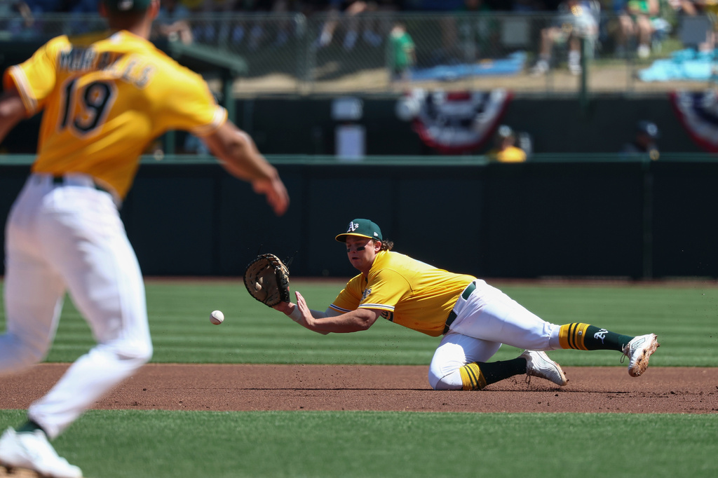 Athletics first baseman Nick Kurtz, right, dives for a ball hit by Houston Astros' Christian Walker (not shown) during the first inning of a baseball game Saturday, April 4, 2026, in West Sacramento, Calif. (AP Photo/Sara Nevis)