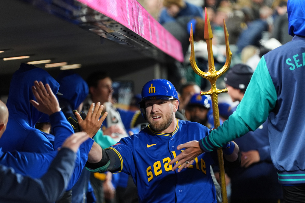 Seattle Mariners' Luke Raley celebrates with the trident in the dugout after hitting a two-run home run against the Cleveland Guardians during the sixth inning of a baseball game, Friday, March 27, 2026, in Seattle. (AP Photo/Lindsey Wasson)