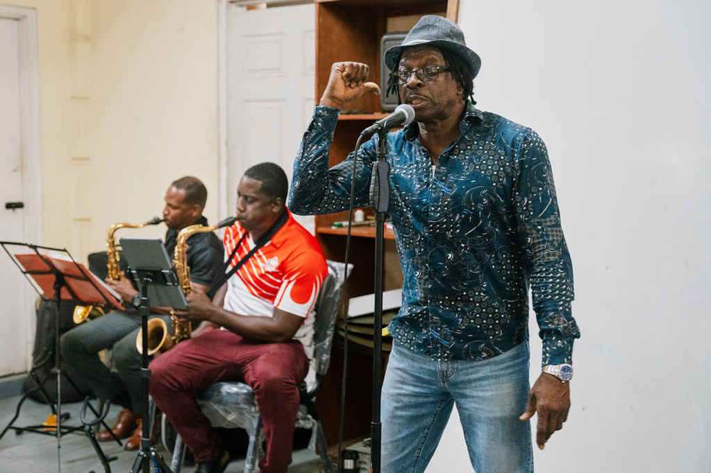 Father Gerard Paul, who can no longer officiate masses, funerals, weddings or baptisms after repeatedly criticizing the church and clergy, rehearses with the Royal Grenada Police Force Band in St. George, Grenada, Thursday, Aug. 6, 2026. (AP Photo/Floyd Robinson)