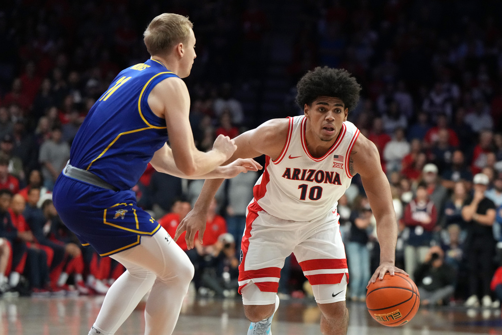 Arizona forward Koa Peat (10) drives past South Dakota State forward Matthew Mors during the first half of an NCAA college basketball game, Monday, Dec. 29, 2025, in Tucson, Ariz. (AP Photo/Rick Scuteri)