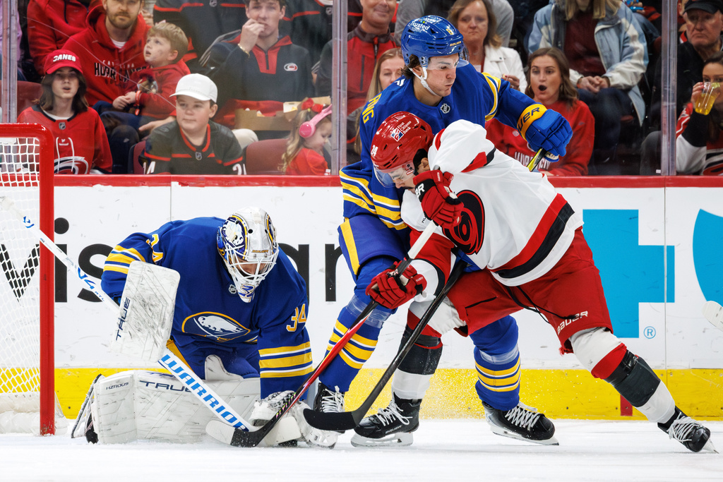 Carolina Hurricanes Seth Jarvis battles with Buffalo Sabres Michael Kesselring and Buffalo Sabres goaltender Alex Lyon in front of the goal during the first period of an NHL hockey game in Raleigh, N.C., Saturday, Nov. 8, 2025. (AP Photo/Ben McKeown)