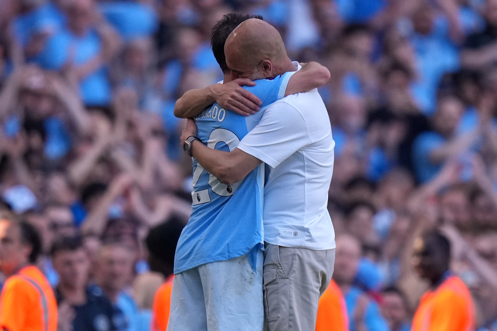 Manchester City's head coach Pep Guardiola hugs Manchester City's Bernardo Silva as he played last match for the team during a Premier League soccer match between Manchester City and Aston Villa in Manchester, England, Sunday, May 24, 2026. (AP Photo/Alastair Grant)