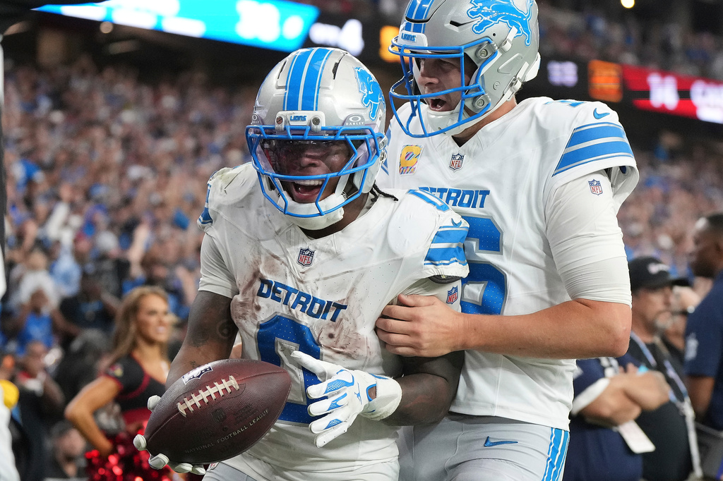 Detroit Lions running back Jahmyr Gibbs (0) celebrates his touchdown run with quarterback Jared Goff (16) against the Arizona Cardinals during the second half of an NFL football game in Glendale, Ariz., Sunday, Oct. 11, 2026. (AP Photo/Rick Scuteri)