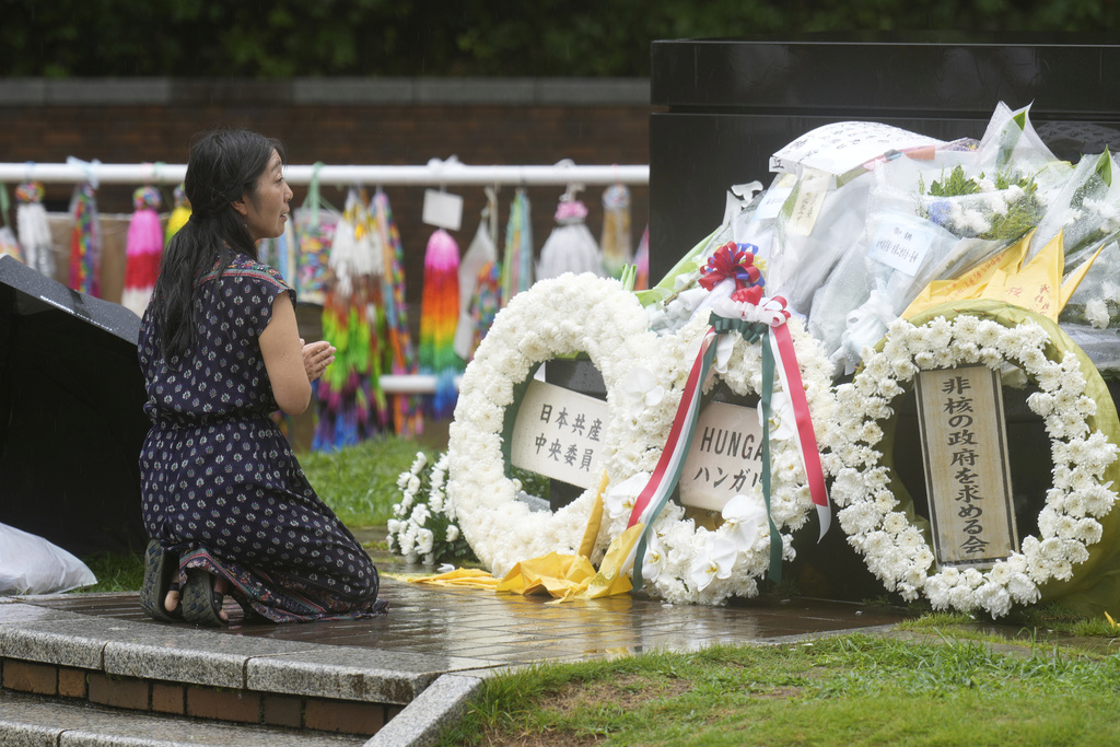 A woman offers prayer in the rain at the Atomic Bomb Hypocenter Park, as Japan commemorates the 80th anniversary of the day an atomic bomb was dropped on its southwestern city, in Nagasaki, Japan Saturday, Aug. 9, 2025.(AP Photo/Eugene Hoshiko)