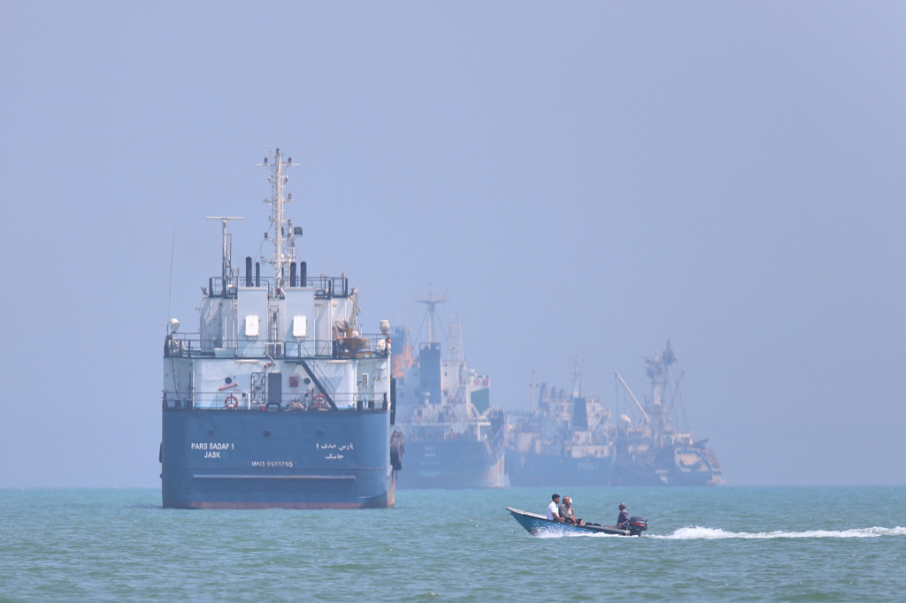 A small motorboat passes anchored vessels in the Strait of Hormuz off Bandar Abbas, Iran, Thursday, June 11, 2026.(Amirhosein Khorgooi/ISNA via AP)