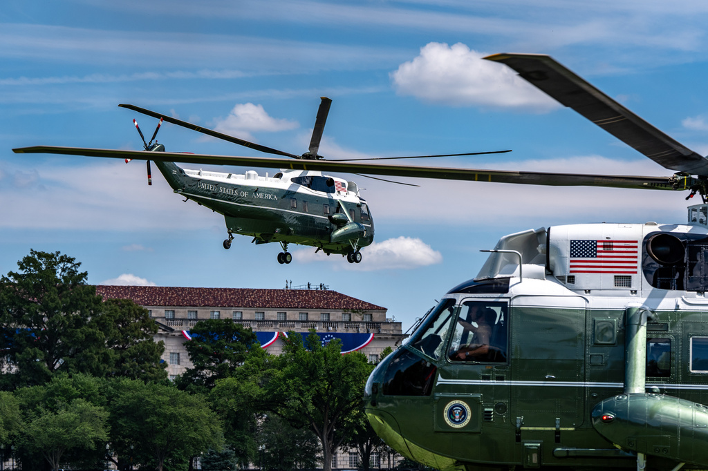 Marine One, left, with President Donald Trump aboard, lifts off from the Ellipse, Tuesday, Aug. 4, 2026, in Washington. (AP Photo/Alex Brandon)