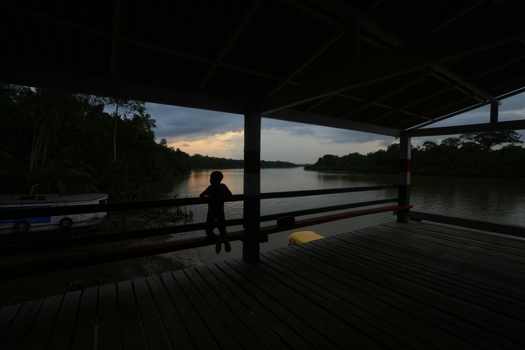A boy waits for a boat at the harbor in Itacoa Miri, Brazil, Tuesday, Nov. 18, 2025. (AP Photo/Fernando Llano)