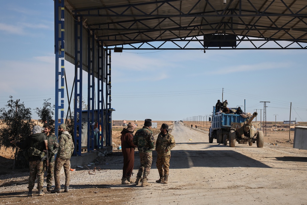 Syrian government troops are seen at an abandoned checkpoint between government-controlled Raqqa and Hassakeh, controlled by the Syrian Democratic Forces (SDF), in northeastern Syria, Jan. 20, 2026. (AP Photo/Omar Albam)