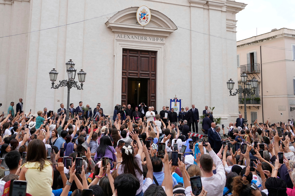 FILE - Pope Leo XIV is greeted by faithful as he arrives at the St. Thomas of Villanova Church to celebrate a mass, in Castel Gandolfo, on the outskirts of Rome, Aug.15, 2025. (AP Photo/Gregorio Borgia, File)
