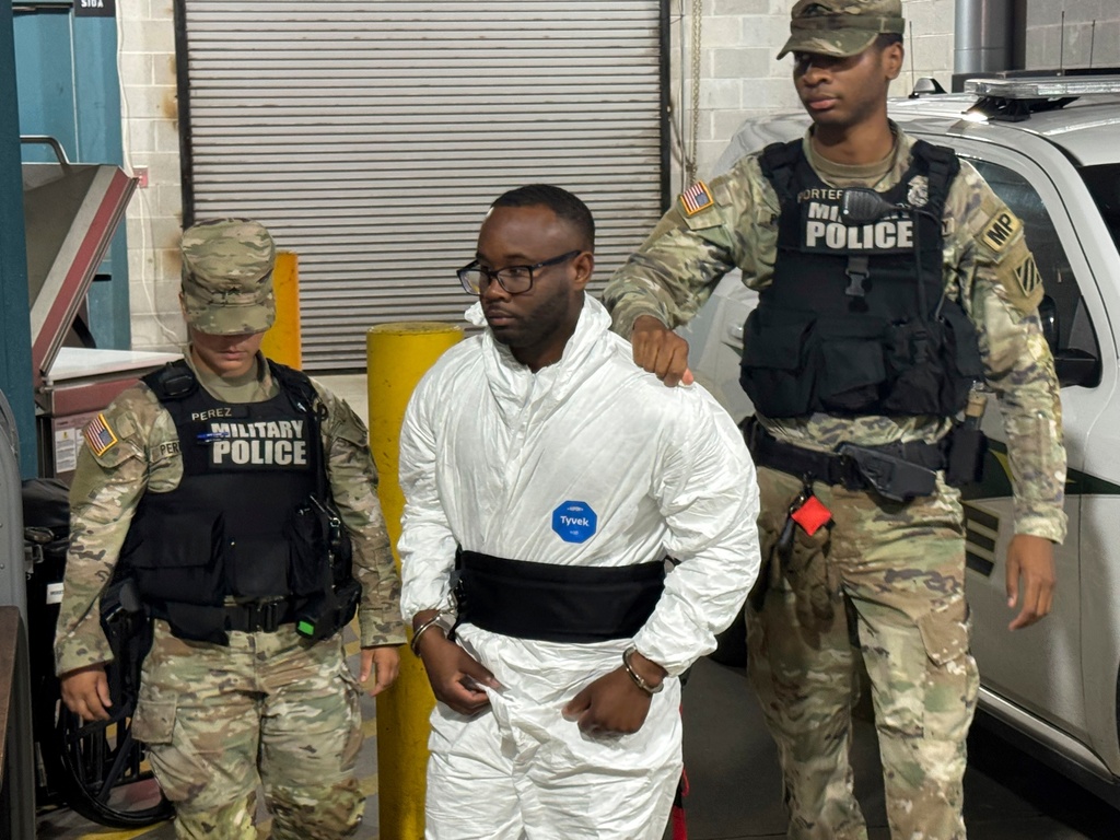 FILE - Sgt. Quornelius Radford, a suspect in the shooting of five soldiers at Fort Stewart, is escorted by military police into a booking room at the Liberty County Jail, in Hinesville, Ga., Aug. 6, 2025. (AP Photo/Lewis M. Levine, File)