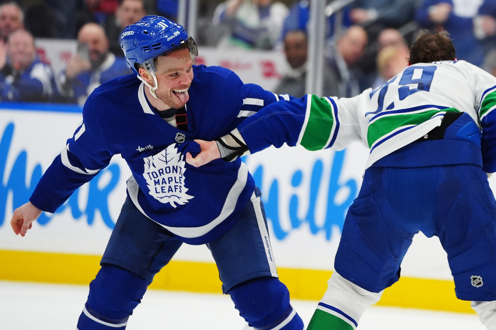 Toronto Maple Leafs' Max Domi, left, and Vancouver Canucks' Marcus Pettersson, right, fight during second-period NHL hockey game action in Toronto, Saturday, Jan. 10, 2026. (Frank Gunn/The Canadian Press via AP)