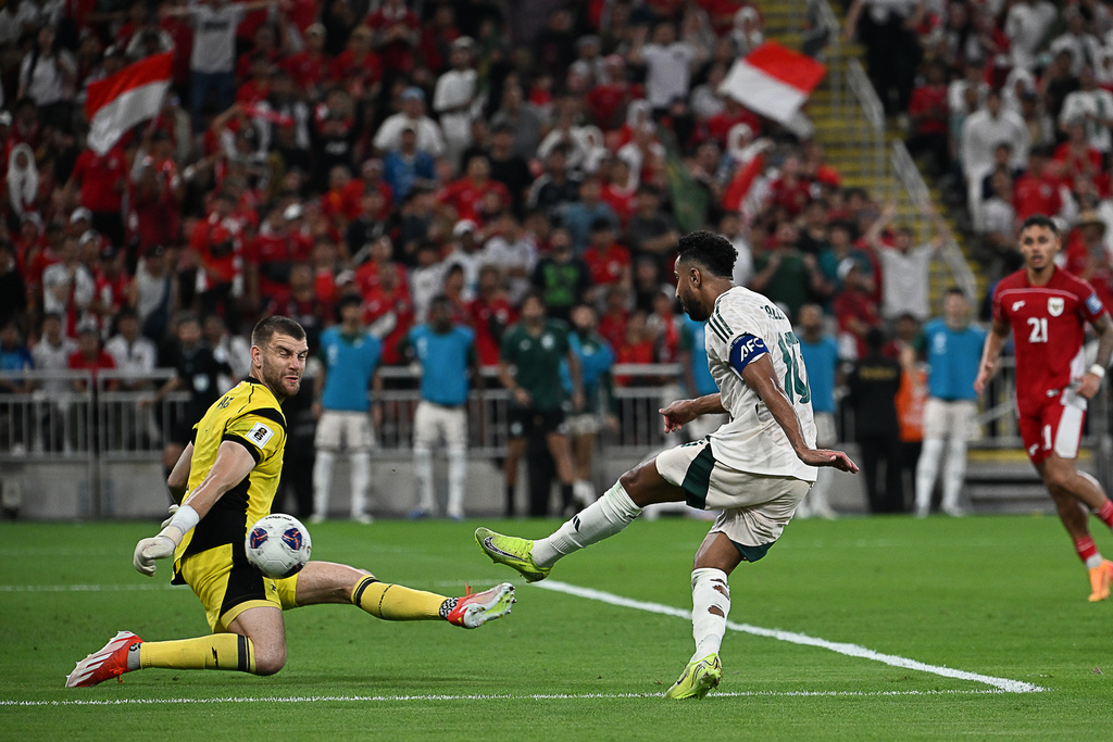 Saudi Arabia's Salem Al Dawsari, right, attempts a shot at goal in front of Indonesia's goalkeeper Maarten Vincent Paes during the World Cup 2026 Asian qualifier fourth-round Group B soccer match between Saudi Arabia and Indonesia at Alinma Bank Stadium in King Abdullah Sports City, in Jiddah, Saudi Arabia, Wednesday, Oct. 8, 2025. (AP Photo)