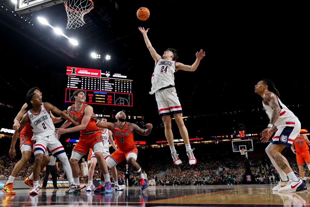 UConn guard Braylon Mullins (24) rebounds against Illinois during the second half of an NCAA college basketball tournament semifinal game at the Final Four, Saturday, April 4, 2026, in Indianapolis. (AP Photo/Abbie Parr)
