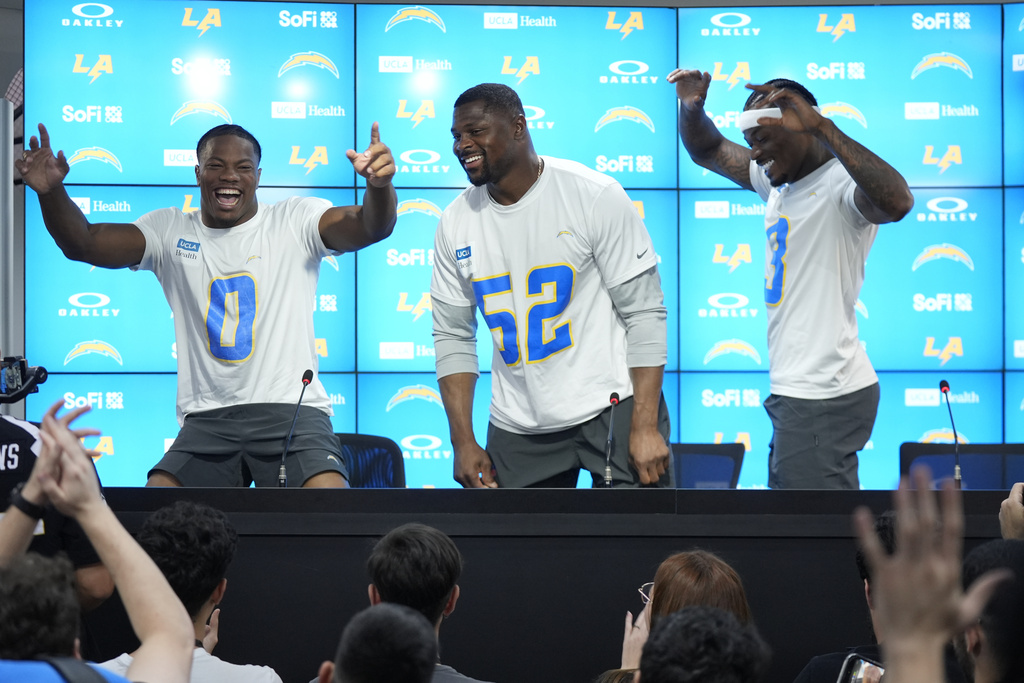 Los Angeles Chargers linebacker Daiyan Henley (0) linebacker Khalil Mack (52) and safety Derwin James Jr. joke with the press during a news conference prior to an NFL football game against the Kansas City Chiefs in Sao Paulo, Wednesday, Sept. 3, 2025. (AP Photo/Fernando Llano)