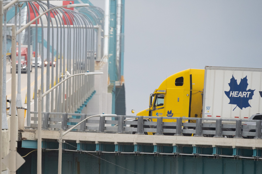 Transport trucks cross the Ambassador Bridge into the United States of America, in Windsor, Ontario, Canada, Saturday, Aug. 22, 2026. (Dax Melmer/The Canadian Press via AP)