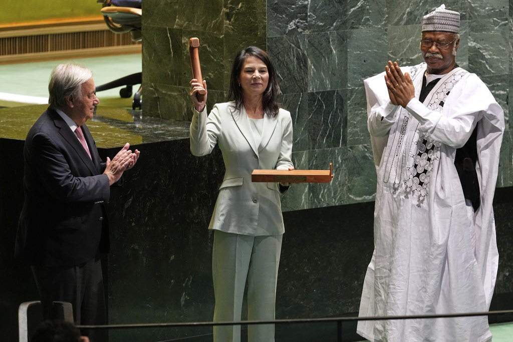 Secretary-General António Guterres, left, and former president of the General Assembly Philemon Yang, right, look on, as Annalena Baerbock, center, holds up a gavel after being sworn in as the president of the 80th session of the United Nations General Assembly at United Nations headquarters, Tuesday, Sept. 9, 2025. (AP Photo/Seth Wenig)