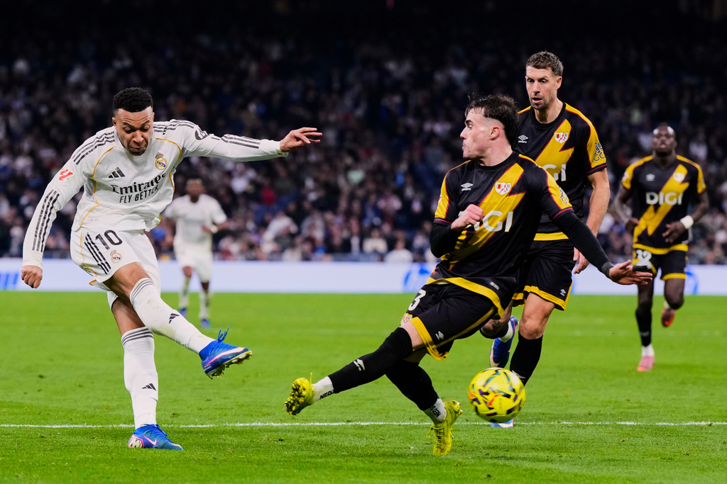 Real Madrid's Kylian Mbappe, left, tries a shot during the Spanish La Liga soccer match between Real Madrid and Rayo Vallecano in Madrid, Spain, Sunday, Feb. 1, 2026. (AP Photo/Manu Fernandez)
