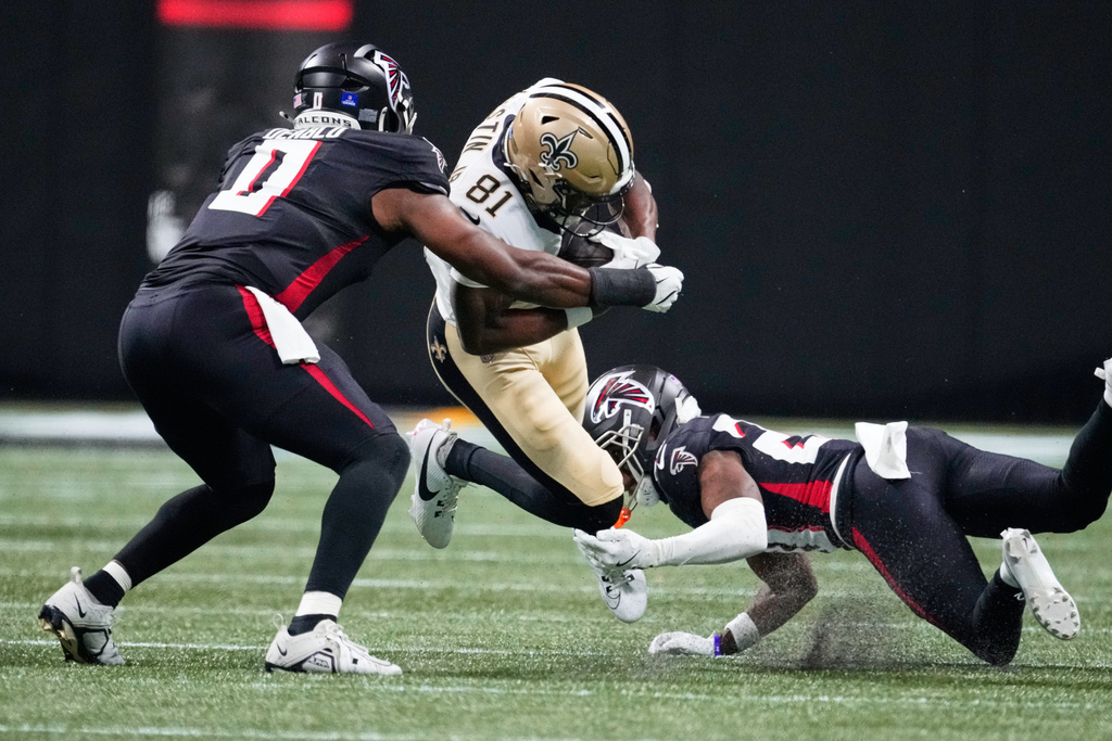 New Orleans Saints wide receiver Kevin Austin Jr. (81) carries between Atlanta Falcons cornerback Dee Alford (20) and linebacker Divine Deablo (0) in the first half of an NFL football game, Sunday, Jan. 4, 2026, in Atlanta. (AP Photo/Brynn Anderson)