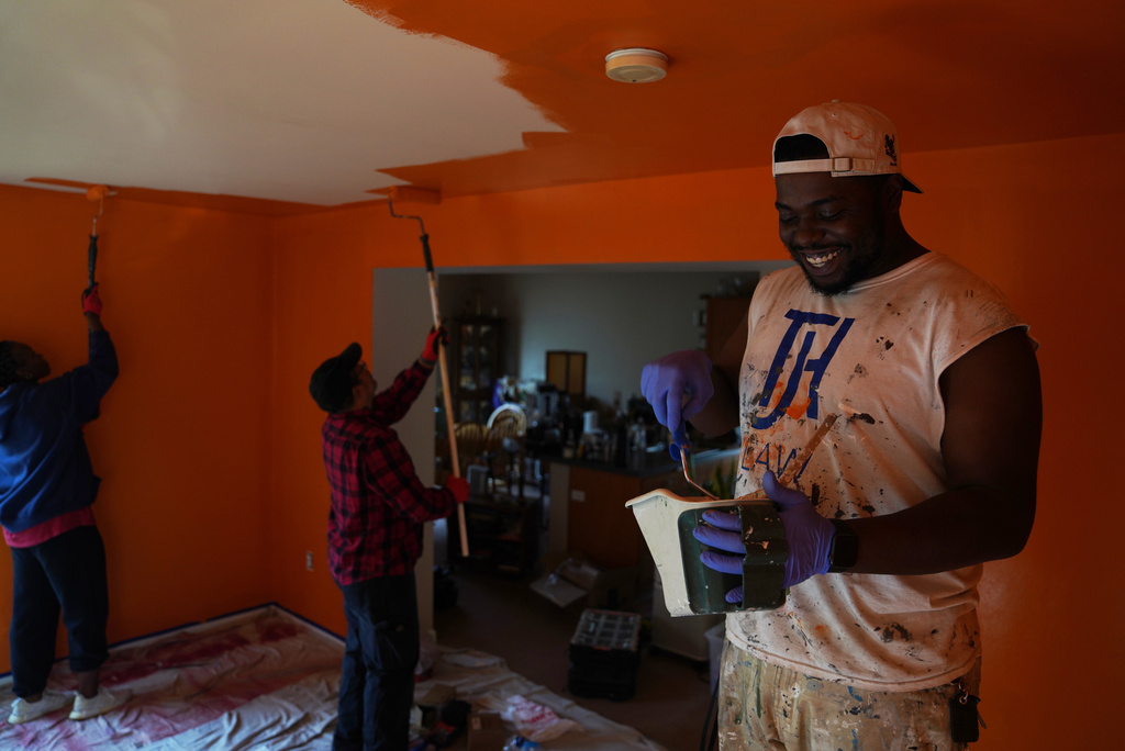 A group from the Neighborhood Resilience Project, an Orthodox social service agency connected to St. Moses the Black Orthodox Church, paints a home in Clairton, Pa., as part of the organization's community-building programs, Monday, Nov. 24, 2025. (AP Photo/Jessie Wardarski)