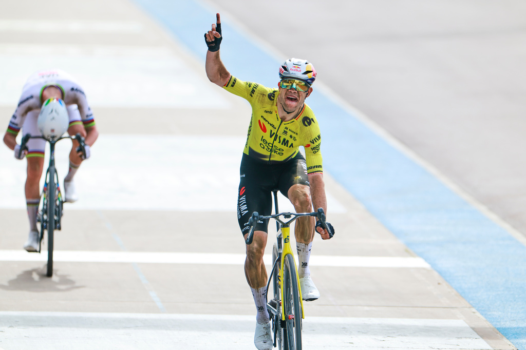 Belgium's Wout van Aert crosses the finish line ahead of Tadej Pogacar of Slovenia, left, to win the Paris-Roubaix cycling race in Roubaix, France, Sunday, April 12, 2026. (AP Photo/Jean-Francois Badias)