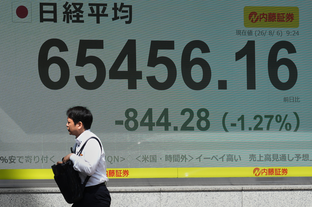 A person walks past an electronic board showing Japan's Nikkei index at a securities firm Thursday, Aug. 6, 2026, in Tokyo. (AP Photo/Eugene Hoshiko)