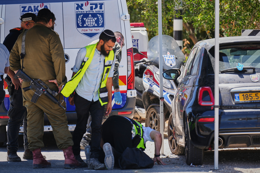 Israeli security forces and ZAKA rescue service volunteers respond at the scene of a shooting attack carried out by a Palestinian citizen of Israel near Tzur Yitzhak in central Israel, Sunday, June 7, 2026. (AP Photo/Ariel Schalit)