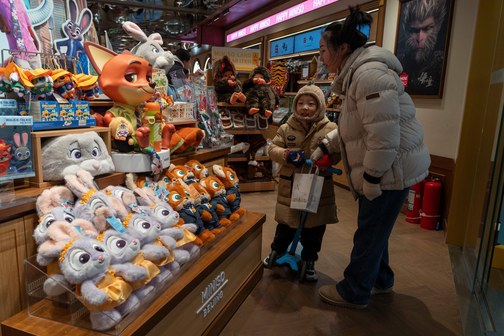 A child walks near the soft toys of characters for Zootopia 2 at a merchandise store in Beijing, China, Tuesday, Dec. 9, 2025.(AP Photo/Ng Han Guan)