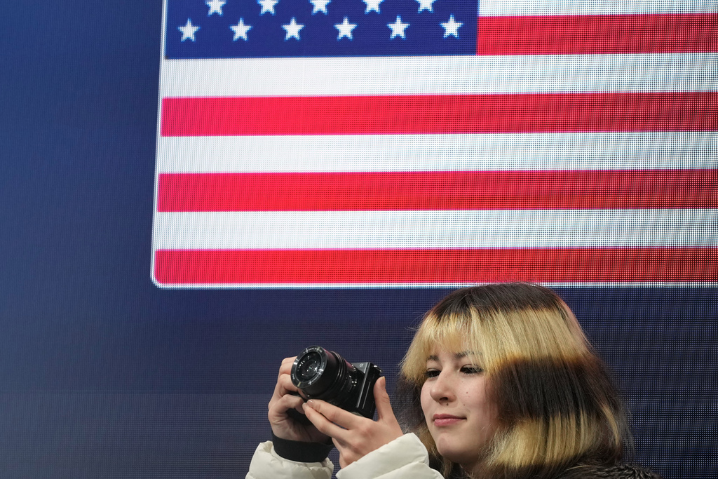 Alysa Liu of the United States takes photos before the figure skating men's team event at the 2026 Winter Olympics, in Milan, Italy, Saturday, Feb. 7, 2026. (AP Photo/Francisco Seco)