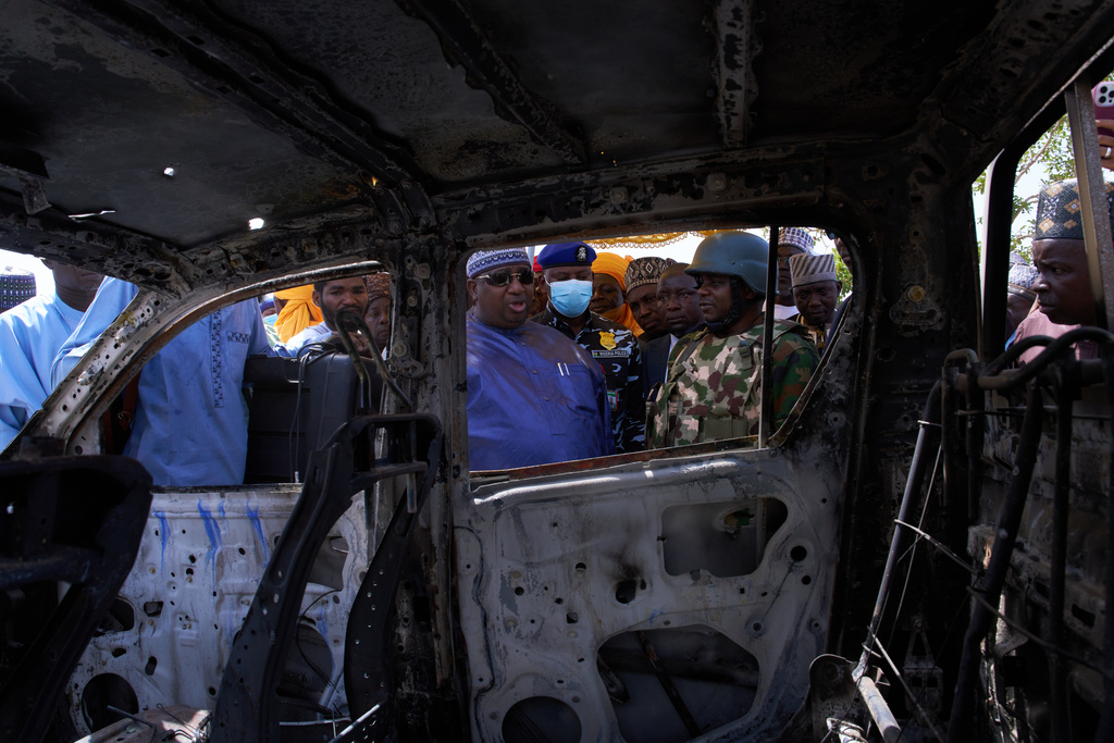 In this photo released by the Kebbi State Government, Governor Nasir Idris, center, inspects a burned military vehicle following a late Tuesday ambush by armed militants in Shanga, Kebbi, northern Nigeria, Wednesday, March 25, 2026. (Kebbi State Government via AP)
