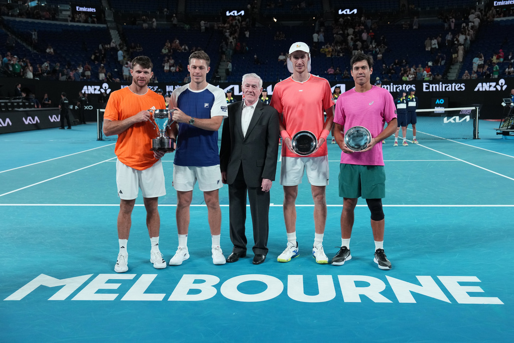 Ken Rosewall, centre, stands with Christian Harrison, left, of the U.S. and Neal Skupski of Britain after they defeated Australia's Jason Kubler, right, and Marc Polmans in the men's doubles final at the Australian Open tennis championship in Melbourne, Australia, Saturday, Jan. 31, 2026. (AP Photo/Aaron Favila)