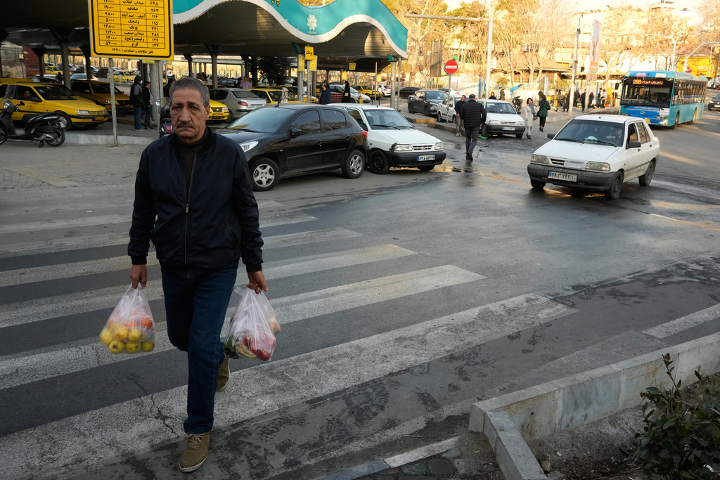 A man carries his items after shopping at Tajrish Square in northern Tehran, Iran, Tuesday, Jan. 27, 2026. (AP Photo/Vahid Salemi)