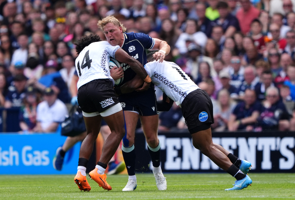 Scotland's Duhan van der Merwe, centre, is tackled by Fiji's Selestino Ravutaumada, left, during the Nations Championship match between Scotland and Fiji, in Edinburgh, Scotland, Saturday July 18, 2026. (Andrew Milligan/PA via AP)