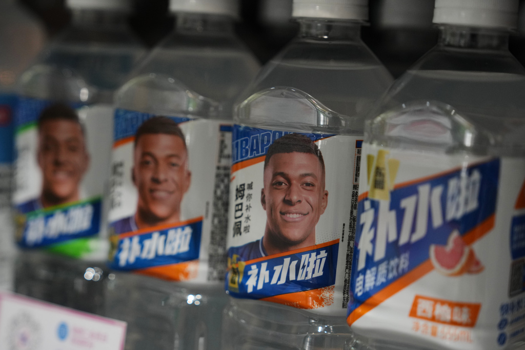 Bottles of electrolyte drink by Dongpeng Beverage Group featuring images of French soccer star Kylian Mbapp&eacute; are displayed for sale at a supermarket in Beijing, Tuesday, Oct. 27, 2026. (AP Photo/Andy Wong)